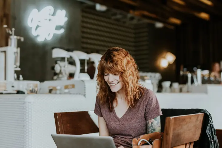 Woman happily chatting on laptop