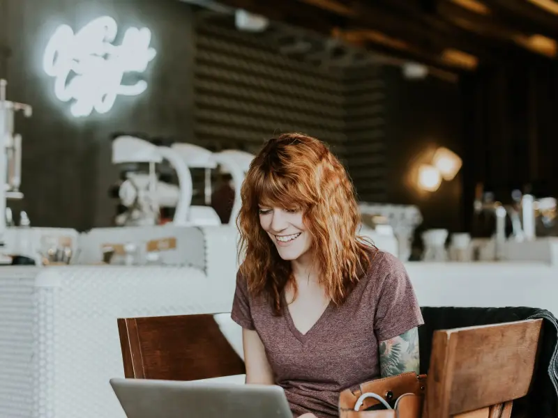 Woman happily chatting on laptop